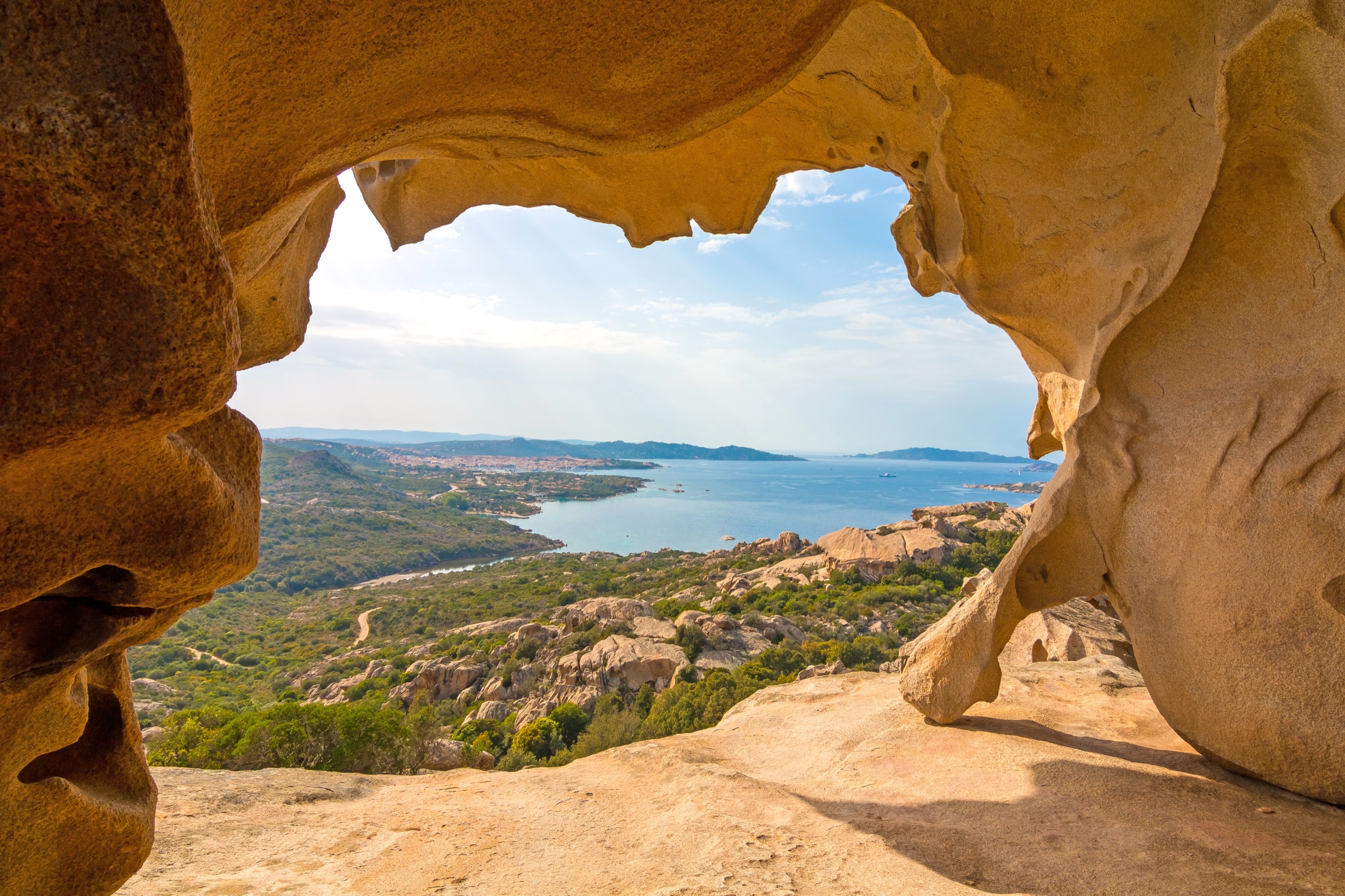 View through the natural arch of Capo d'Orso, looking out over the archipelago