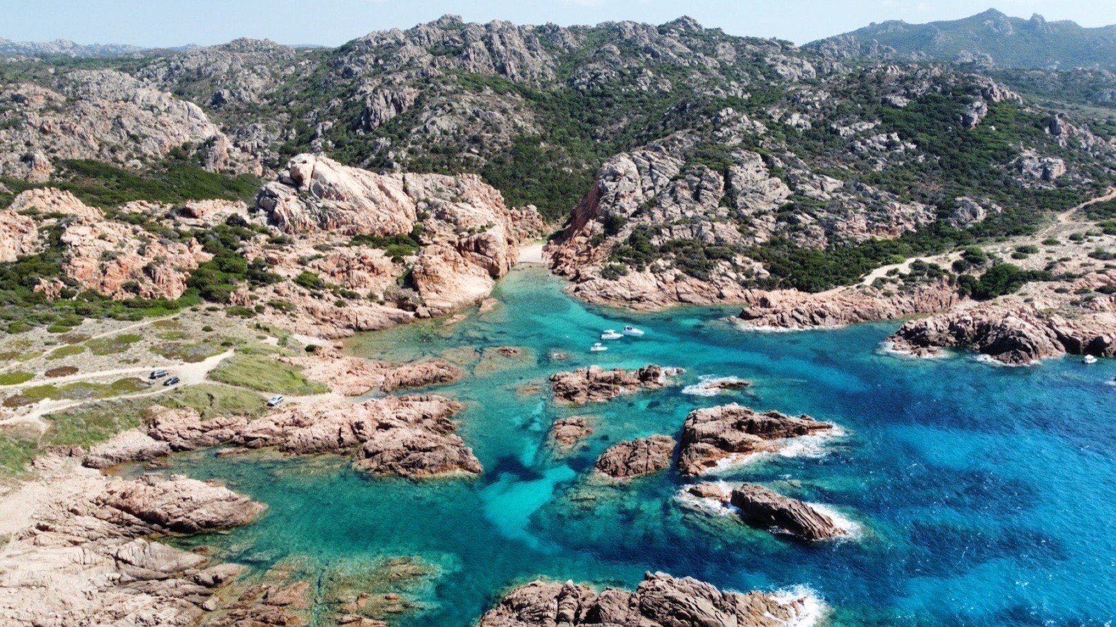 Cala Sarraina seen from the cliff path, pink granite framing the cove