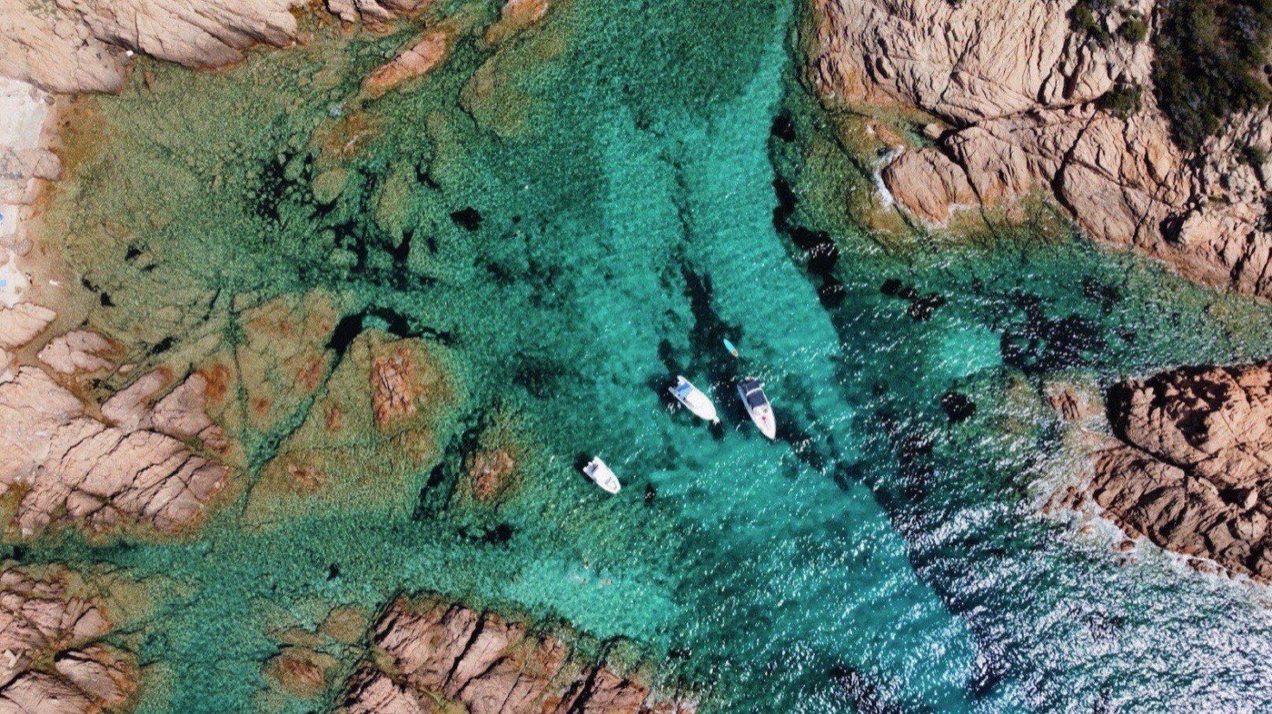 Clear water around the granite rocks at the edge of Cala Sarraina
