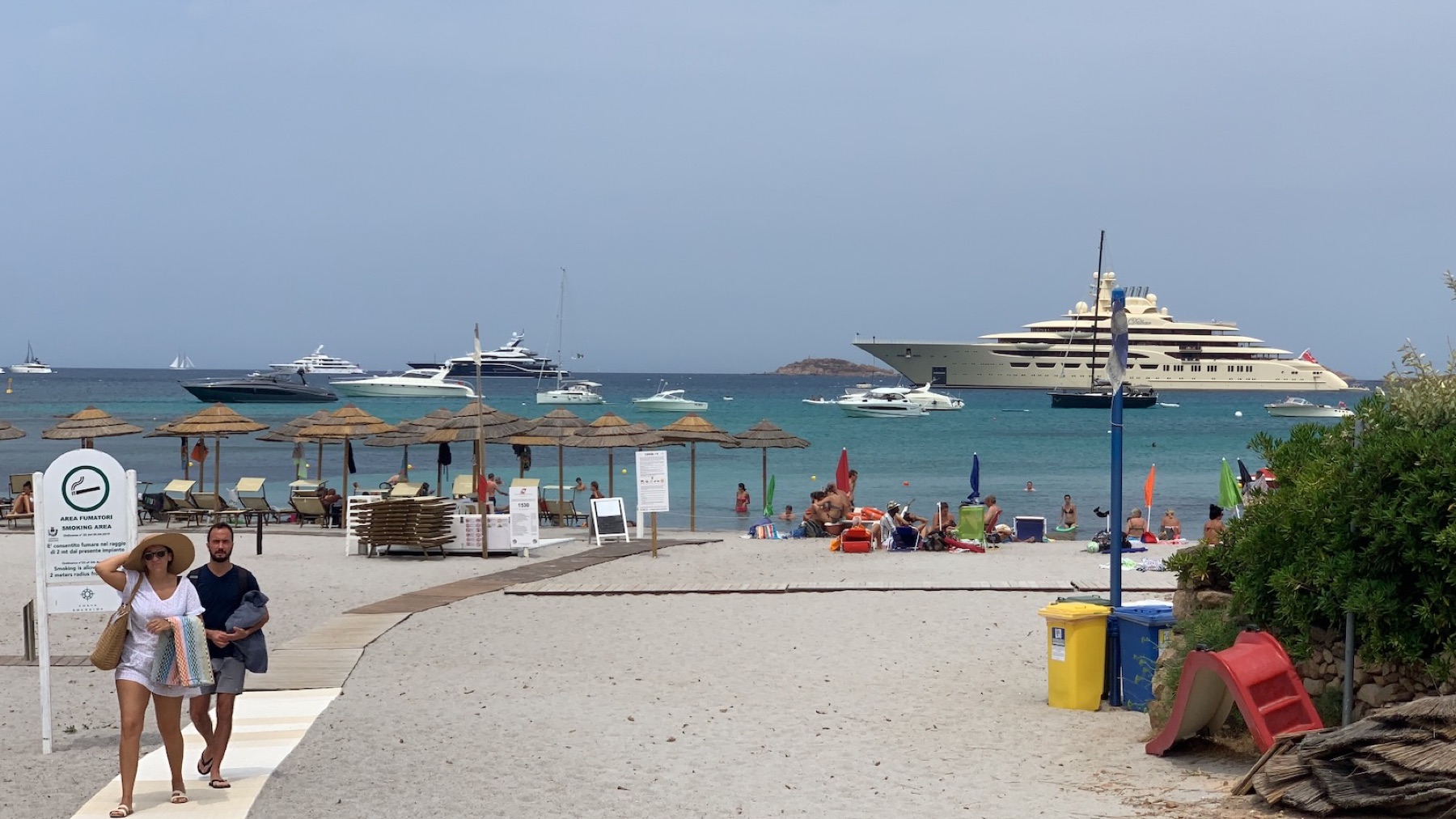 Costa Smeralda beach with sunbeds, yachts on the horizon