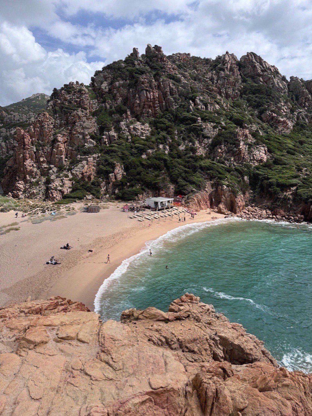 Li Cossi beach seen from above, framed by pink-granite cliffs