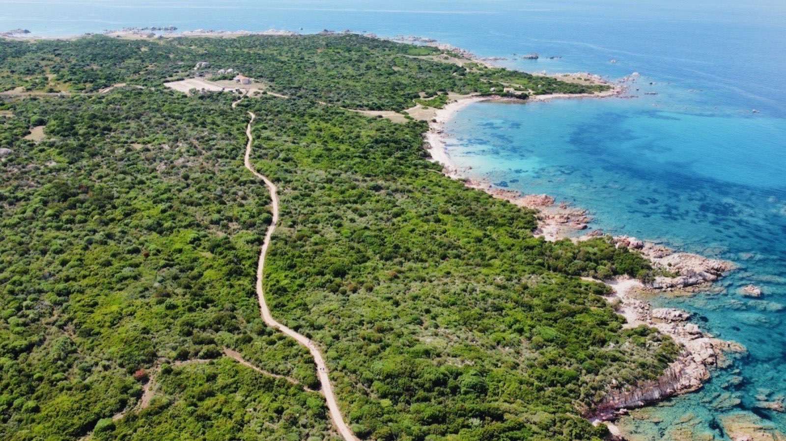 Aerial of the coast path linking Portobello di Gallura to Vignola Mare, with the granite shore on the right