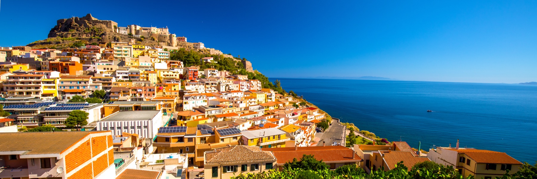 The cluster of colourful houses climbing the rock in Castelsardo