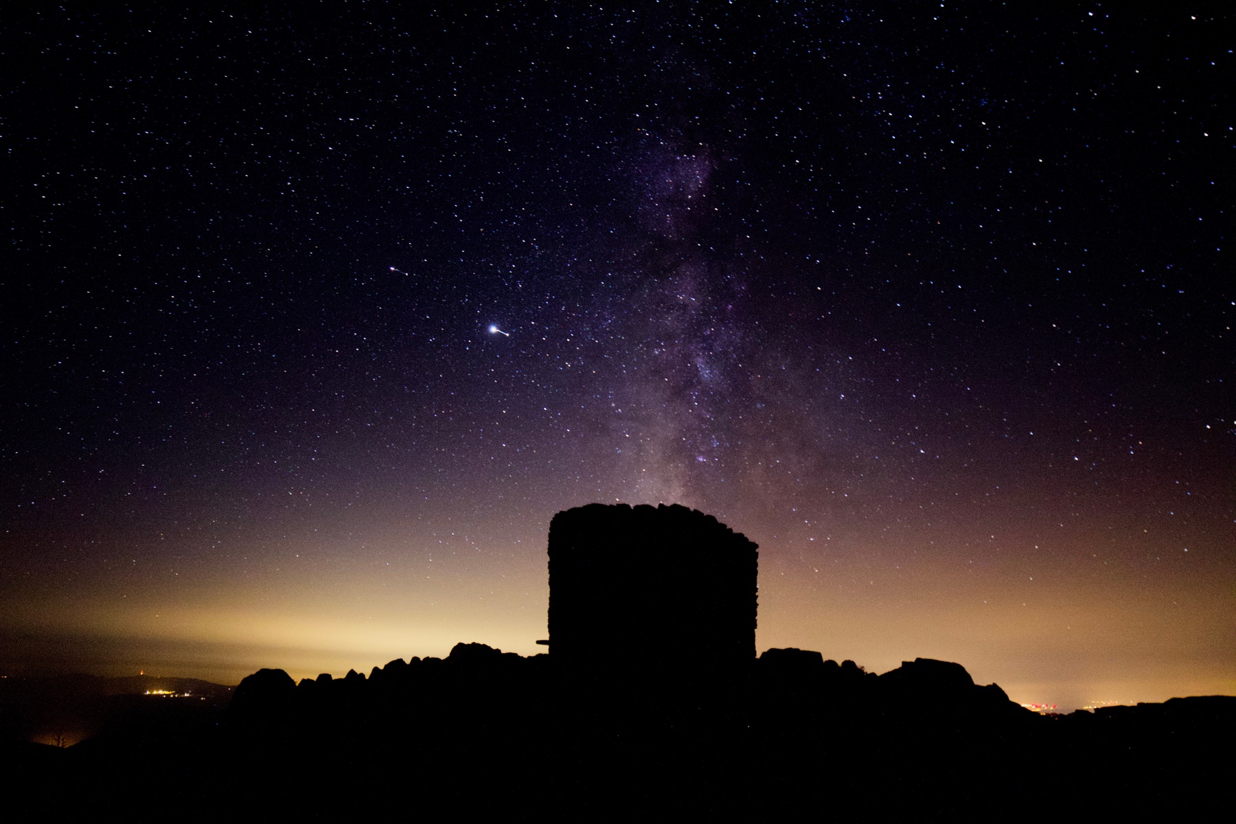 A nuraghe silhouetted against a starry night sky